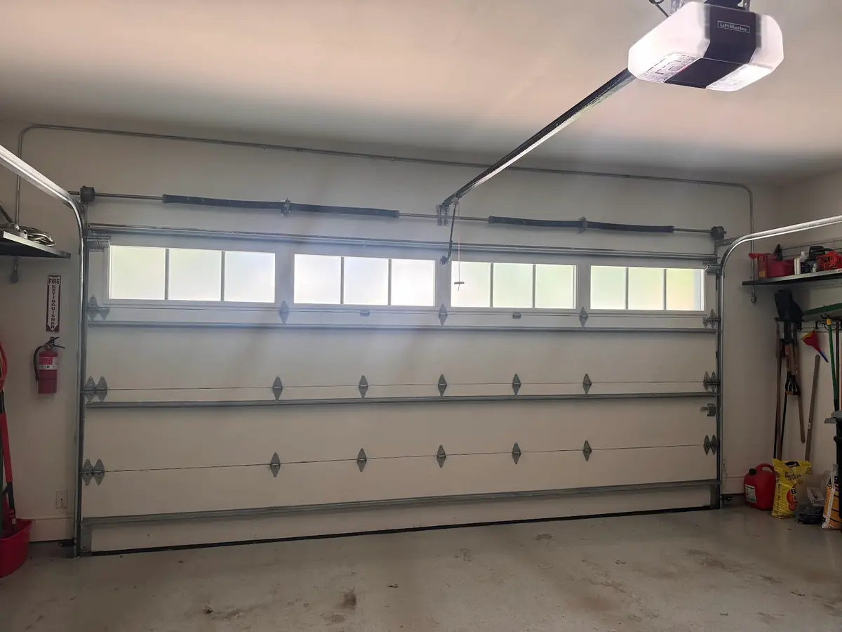 Ceiling-mounted opener above a residential garage door
